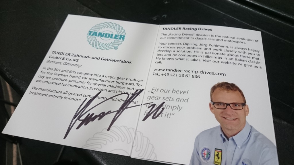 Die Informationsbroschüre für TANDLER Racing Drives enthält Unternehmensdetails, eine Unterschrift und ein Foto eines Mannes mit Brille und Marken-Shirt beim Race Retro 2016. Der Text hebt die Herstellung von Getriebesätzen und Kundenkontaktinformationen hervor.