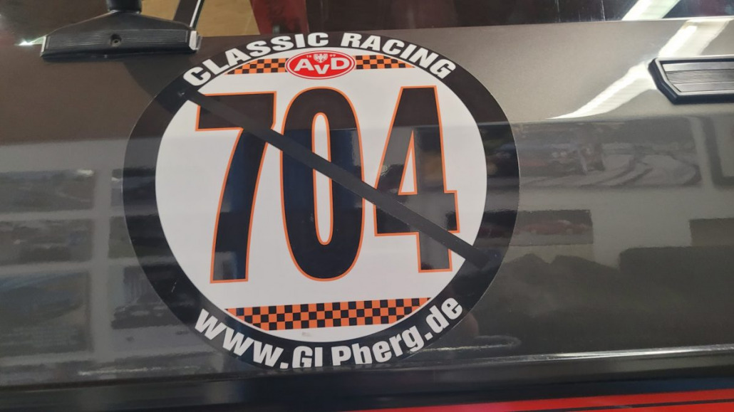 Nahaufnahme einer Autotür mit einem großen, runden Rennaufkleber mit der Nummer 704 und der Aufschrift „Classic Racing“ und „www.GIPberg.de“.